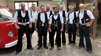 Das Team von Holzbau Bruder in Zimmermannskluft beim 60-jährigen Firmenjubiläum in der Werkhalle